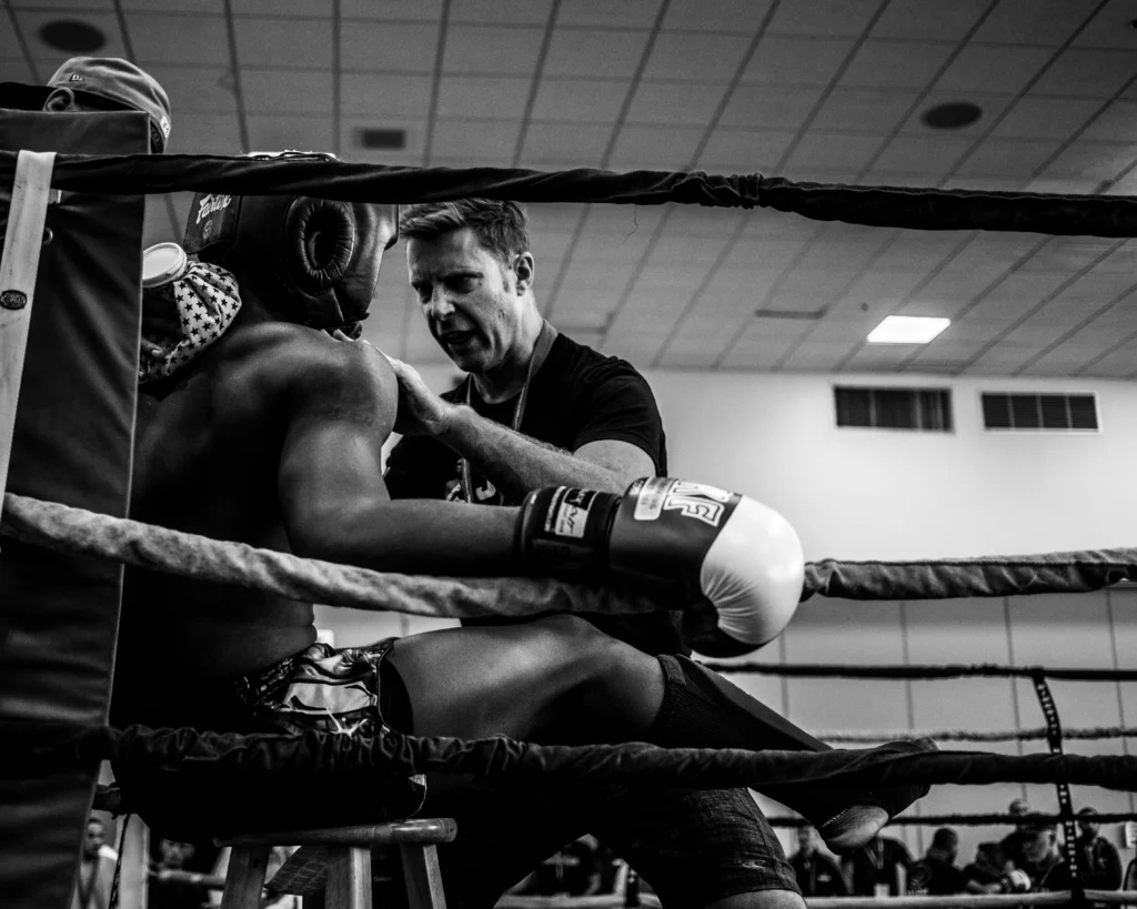 A coach mentoring a boxer in the ring